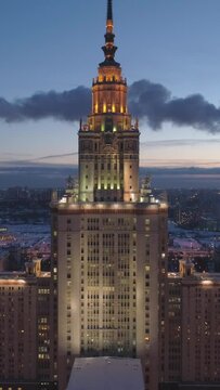 Moscow State University and Illuminated Moscow Skyline at Frosty Winter Evening. Russia. Aerial View. Drone is Flying Backward and Upward. Establishing Shot. Vertical Video