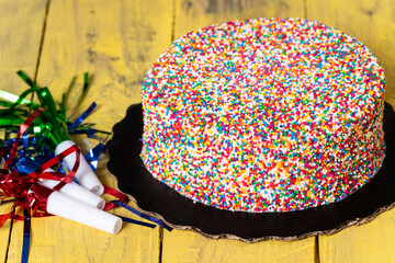 Close-up shot of white icing cake encrusted in multi-colored sprinkles. Celebration concept. 