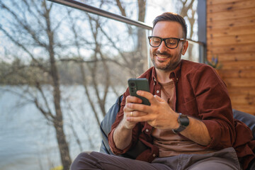 One adult man at home use smart phone app browse internet or send sms