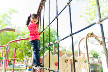 Happy young girl playing outdoors in the playground