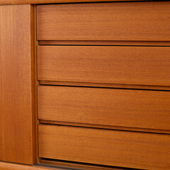 Late-Century teak credenza. Vintage wooden sideboard. Indoor detail photograph. 