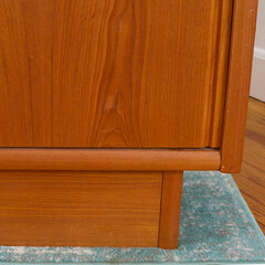 Late-Century teak credenza. Vintage wooden sideboard. Indoor detail photograph. 