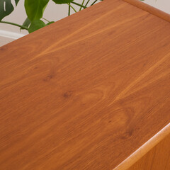 Late-Century teak credenza. Vintage wooden sideboard. Indoor detail photograph. 