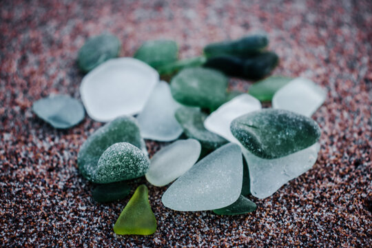 Sand beach and glass stones concept photo. Glass stones from broken bottles polished by the sea