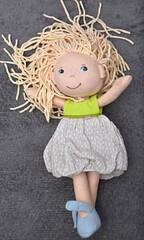 rag doll in a dress with long hair on a gray background