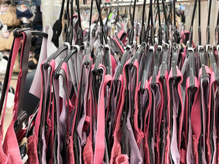 Row of bras hanging in lingerie store, colorful bra straps close up, health