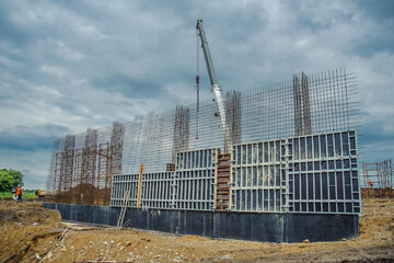 Wall form panels bonded clamp on the background of a crane and clouds