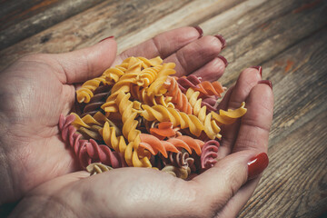 Raw pasta in the hands of a girl, pasta for cooking