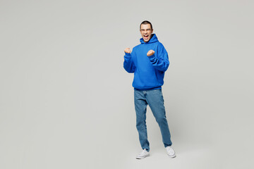Full body happy young middle eastern man he wear blue hoody casual clothes doing winner gesture celebrate clenching fists isolated on plain solid white background studio portrait. Lifestyle concept.