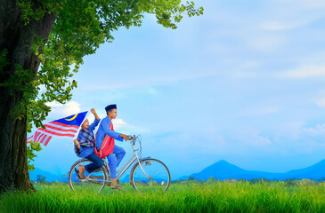 person riding a bicycle holding malaysia flag. Independence concept and traditional culture.