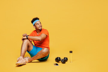 Full body fun young fitness trainer sporty man sportsman wear orange t-shirt use smart watch to...