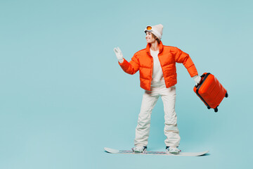 Traveler woman she wear padded windbreaker jacket ski goggles mask hold suitcase bag snowboard...