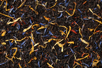 Black tea with dried flower leaves full frame as background close up