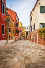 cozy narrow street with colorful houses in Venice early in the morning. Journey