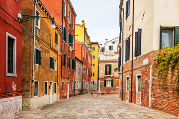 Fototapeta na wymiar cozy narrow street with colorful houses in Venice early in the morning. Journey