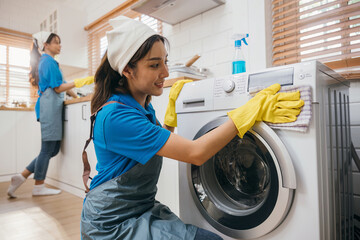 Woman hand in protective glove cleans and wipes washing machine. Highlighting regular housework and...
