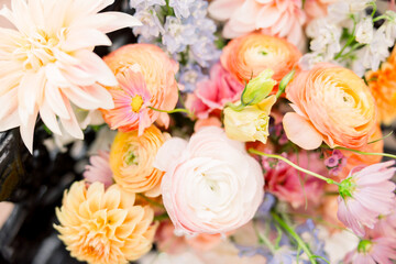 A gorgeous wedding bridal bouquet with roses, daisies, and other delicate and dainty flowers and wildflowers.