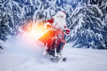 Santa Claus in red cloth riding on snow bike, motorcycle with ski background snow forest. Concept...