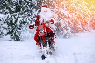 Fotobehang Biker Santa Claus fast delivering Christmas gifts on snow bike, motorcycle ski background snow forest, sunlight © Parilov