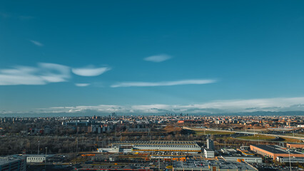 Fototapeta premium View fashion capital Milan against a blue sky from a drone in December. Drone view of Milan from San Donato Milanese. Metro station San Donato M3 Milano.