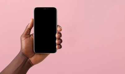 Fototapeta na wymiar Hand holding a smartphone on a pink background