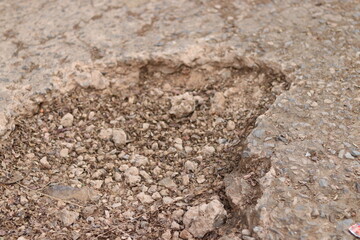 Small Gravel stones falling from damaged or broken ground roads, closeup