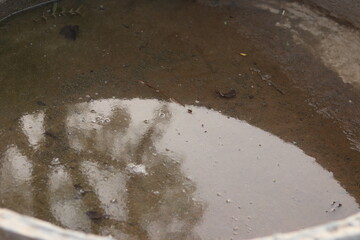 An old Traditional vintage stone or cement water well corner of cattle filled with water, circular well closeup