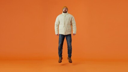 Cold freezing man dressed in jacket jumping and changing outfit into summer clothes