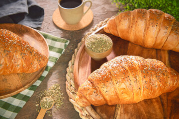 Delicious fresh baking croissant with thyme on top. Served with cup of coffee.