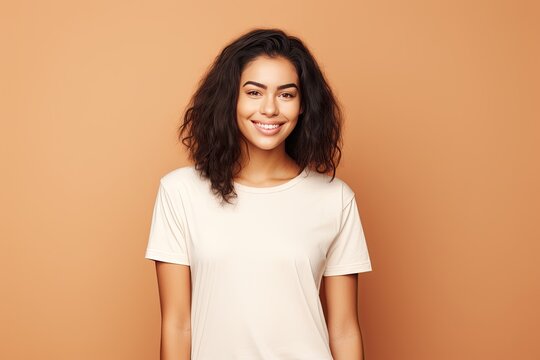 Happy young woman wearing white t-shirt on beige background
