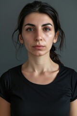 Mugshot of a young caucasian woman looking at the camera on gray background - obrazy, fototapety, plakaty