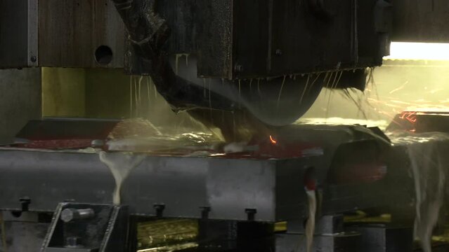 Work of an industrial surface grinding machine. Sparks fly out from under the grinding wheel. Automatic cnc surface grinding wheel machine working with sheet metal with sparks at factory, plant. 
