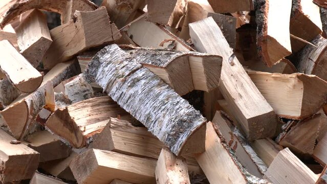 Dry split birch wood for the fireplace, stove, fire. Harvesting firewood for the winter. Large pile of firewood. Birch wood for heating in fireplaces and furnaces