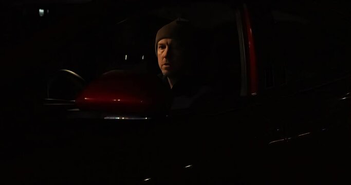 Video clip of an adult male behind the wheel of his car, just pulled over by the police, hurrying to put on his seat belt before the officer arrives