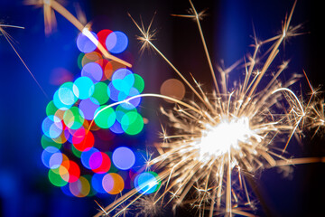 Sylvester New Year, New Year's Eve 2024 party event celebration holiday greeting card - Closeup of sparkling sparklers and bokeh lights in the background - obrazy, fototapety, plakaty