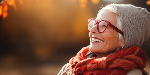 Joyful senior woman enjoying autumn warmth outdoors. Aging gracefully.