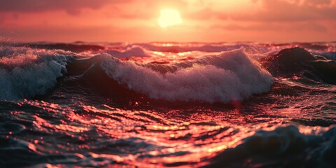 Fototapeta premium A beautiful sunset scene with the sun setting over the waves in the ocean. This image can be used to depict serenity and tranquility