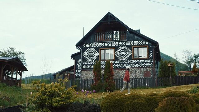 Young Women walking in Village Cicmany, decorated with traditional folk white paint patterns, Slovakia