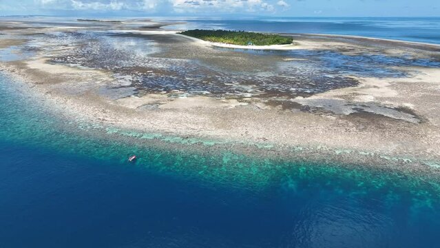 Clear water covers a beautiful reef surrounding the remote island of Koon near Seram, Indonesia. This scenic island's coral reefs, and the surrounding seas, support extraordinary marine biodiversity.