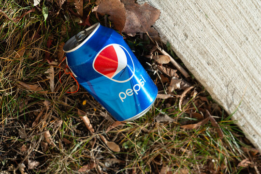 dented pepsi can discarded on the ground