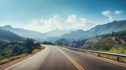 Fototapeta premium Curving road through a mountainous landscape on a clear day