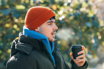 young man wrapped up in winter breathing halo of cold