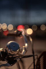 close-up of a bicycle saddle with blurred city light in the background