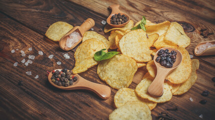 Lots of crispy chips and spices on a wooden surface, fast food and snacks