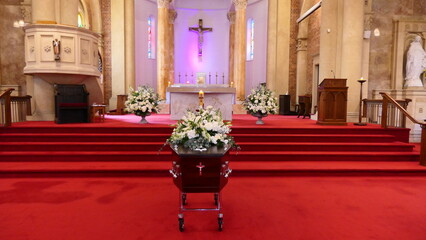 closeup shot of a funeral casket or coffin in a hearse or chapel or burial at cemetery
