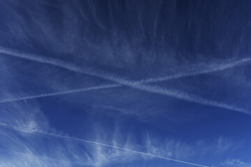 A skyscape with several traces of aviation fuel trails