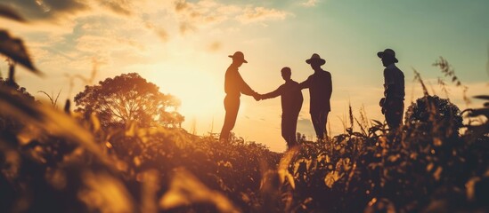 Farmers and business people shake hands to symbolize teamwork and the successful conclusion of a deal. - obrazy, fototapety, plakaty