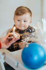 Toddler celebrating birthday looking at candle