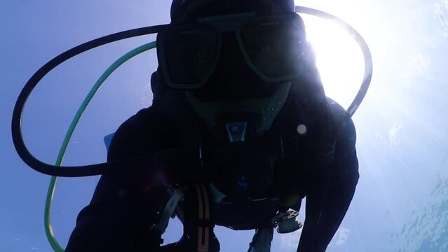 primer plano o selfi de persona buceando con equipo de Scuba descendiendo hacia el fondo en el mar caribe.