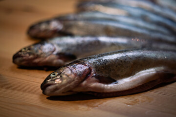 Fresh trouts on the wooden board.